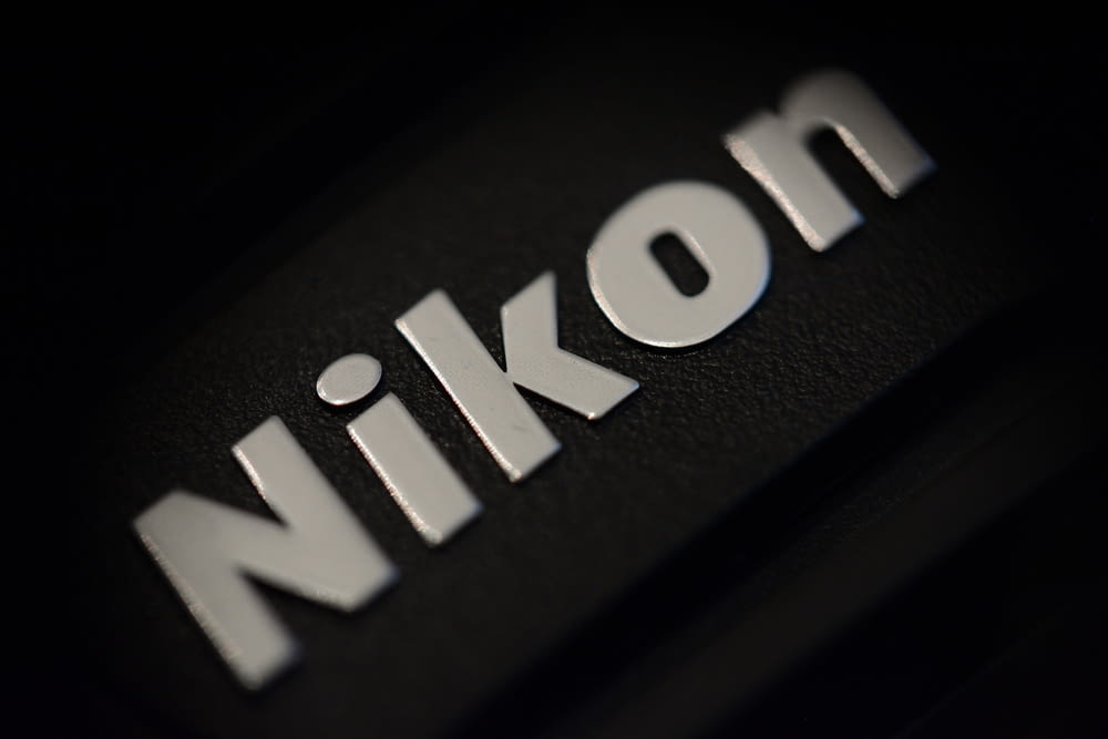 a close up of the word nikon on a black surface