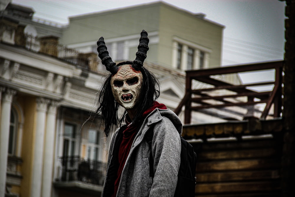 a man wearing a horned mask with long black hair