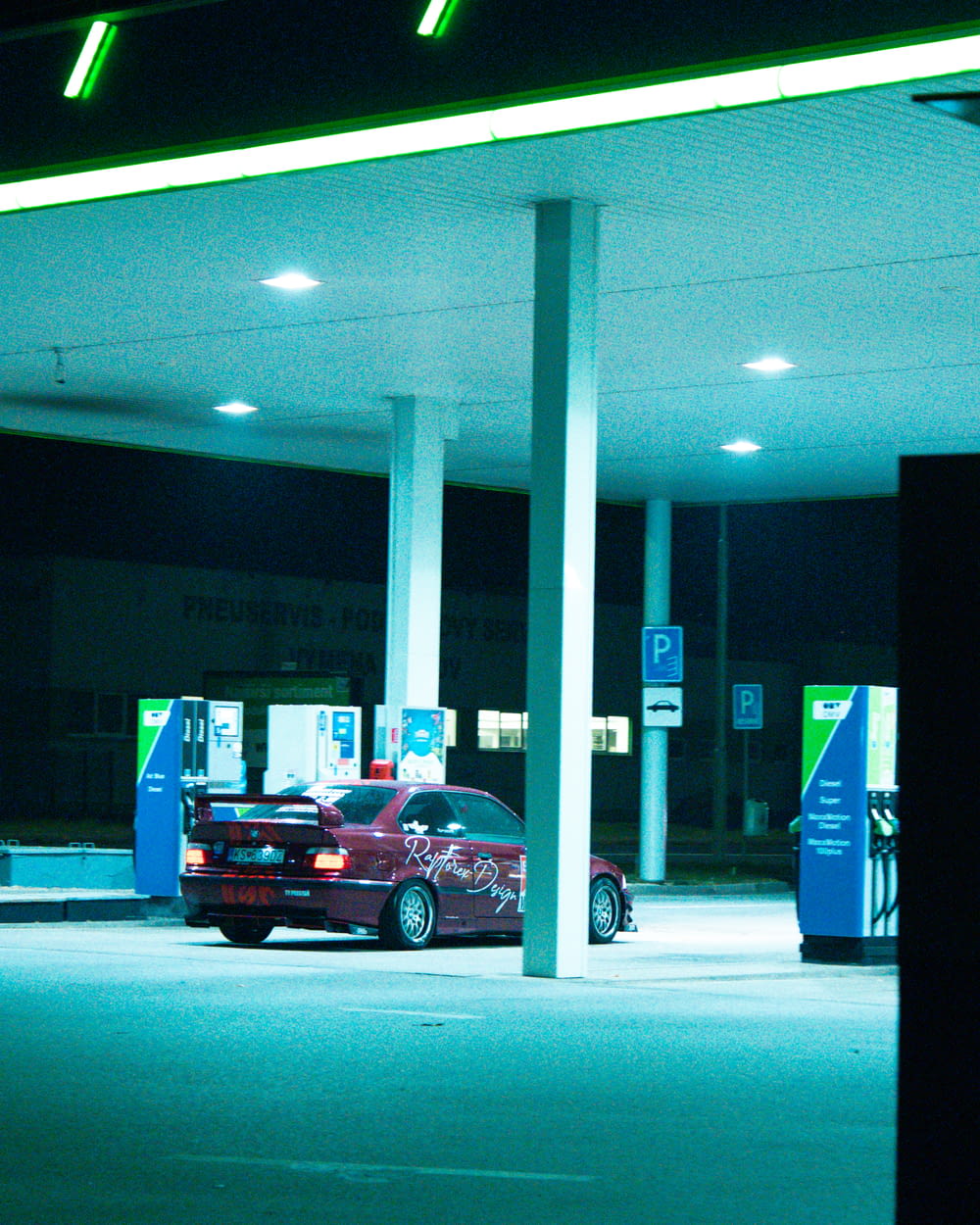 a red car is parked at a gas station