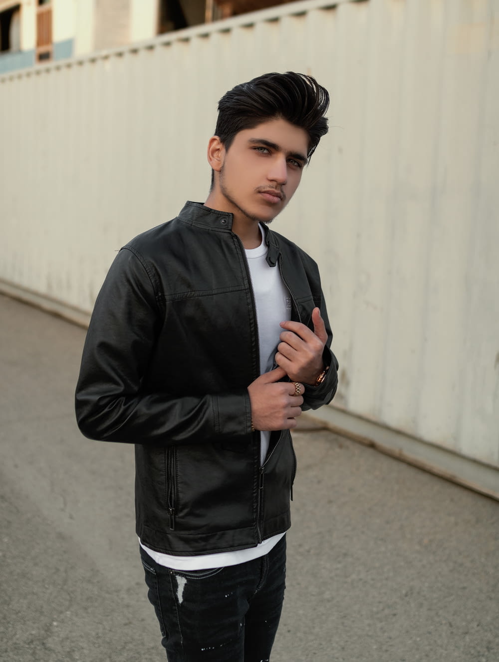 a young man wearing a black leather jacket