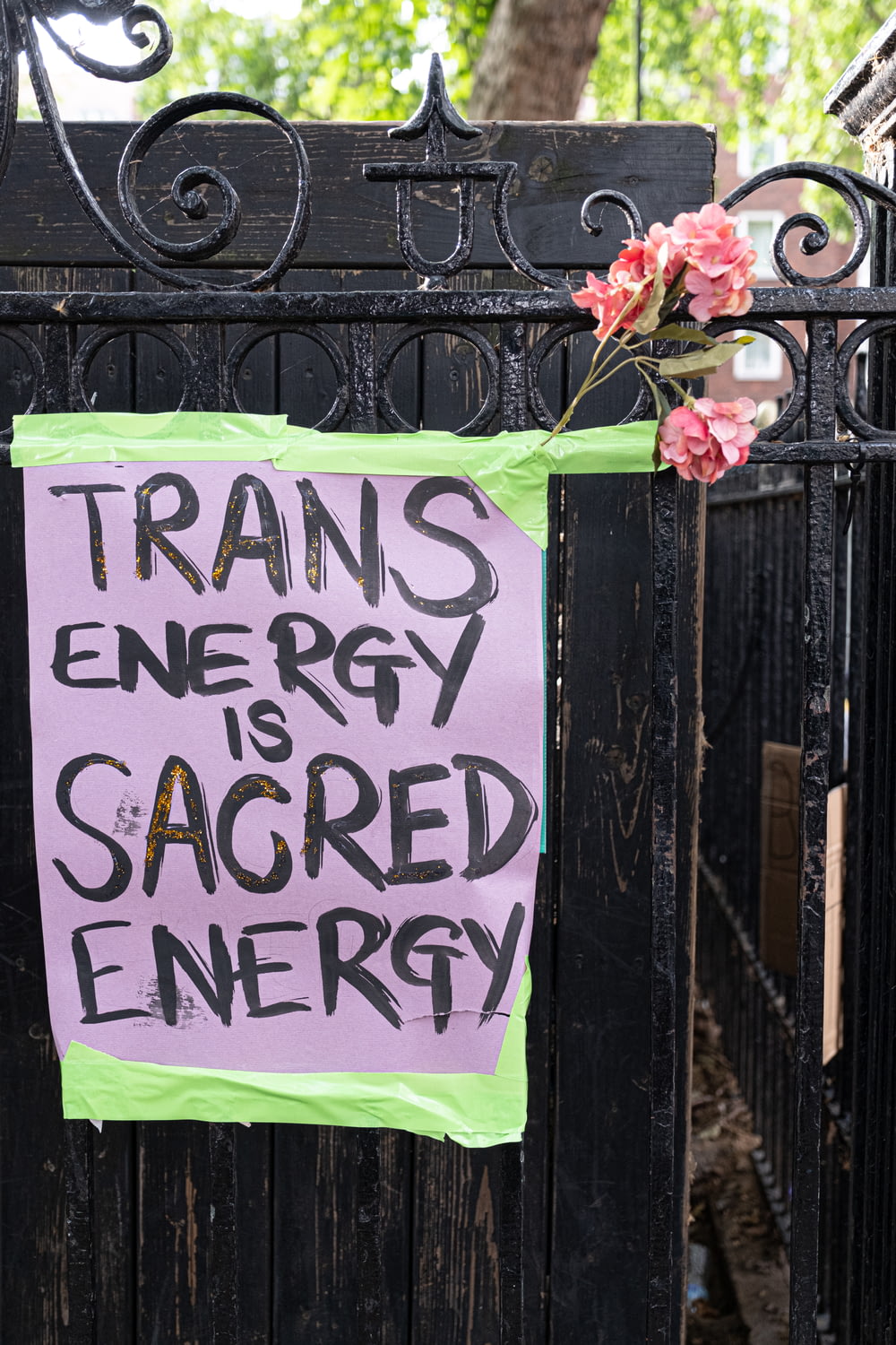 a sign on a gate that says transs energy is sacred energy