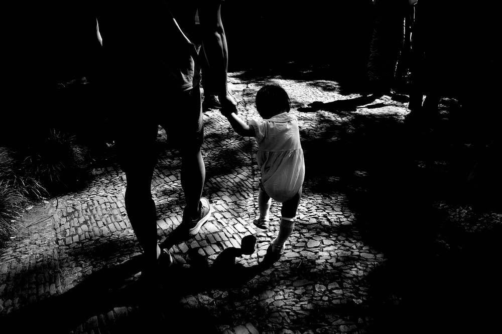 a man and a child are walking in the dark