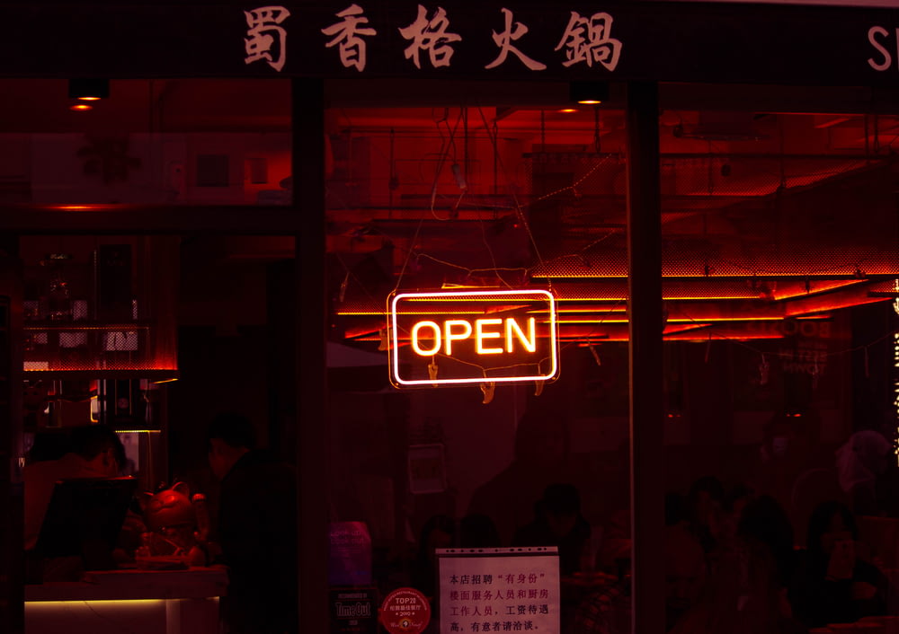 a neon sign that reads open in a window