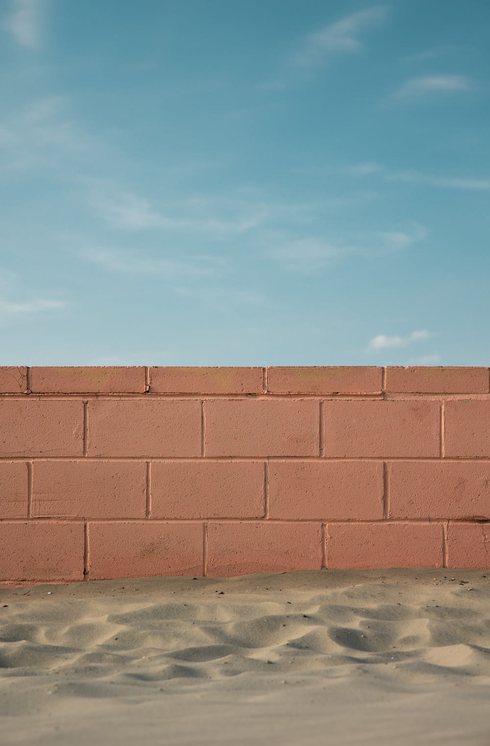 a red brick wall with a blue sky in the background
