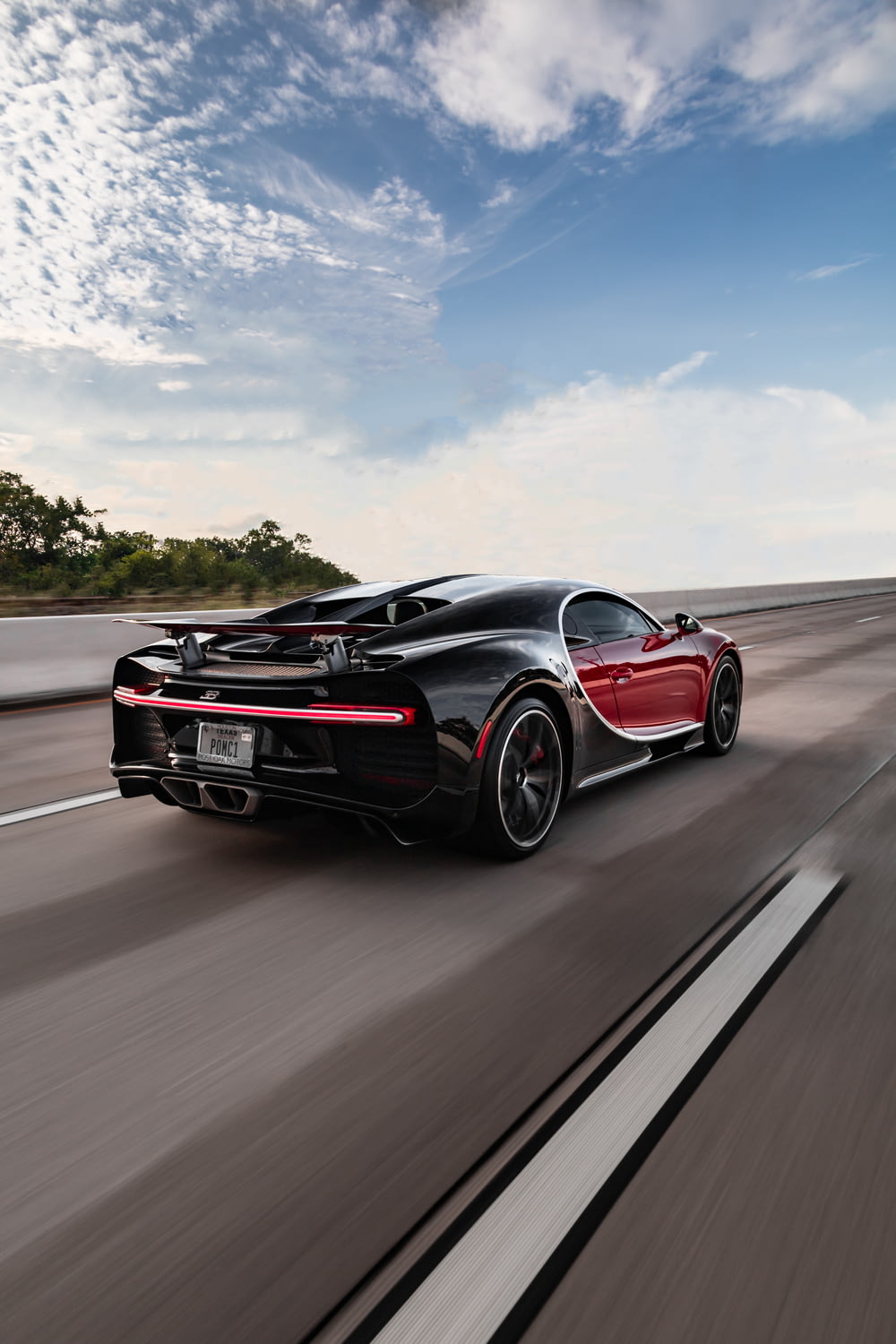 a black and red sports car driving down the road