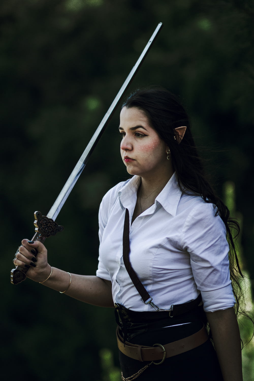 a woman in a white shirt holding a sword