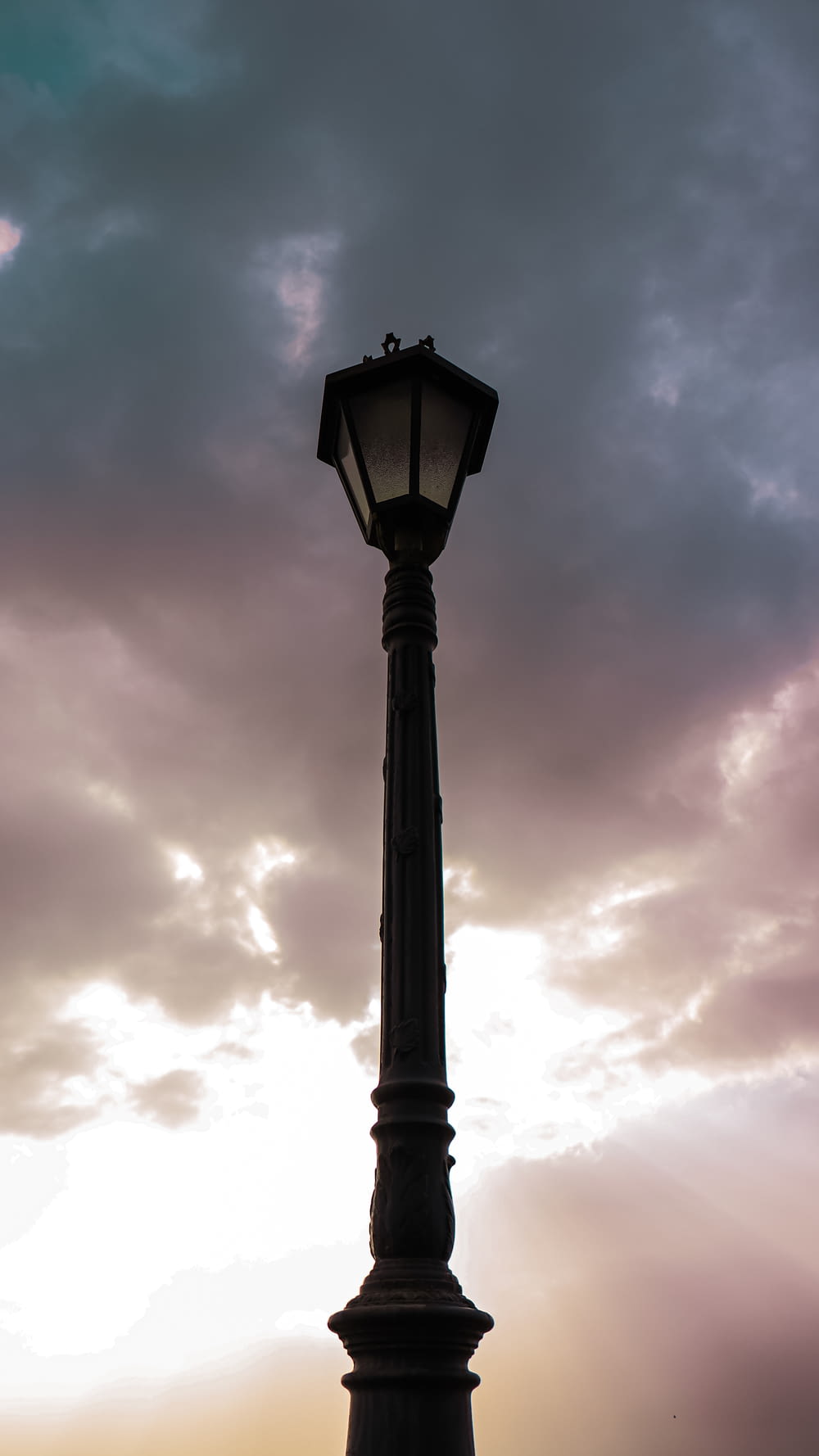 a lamp post with a cloudy sky in the background