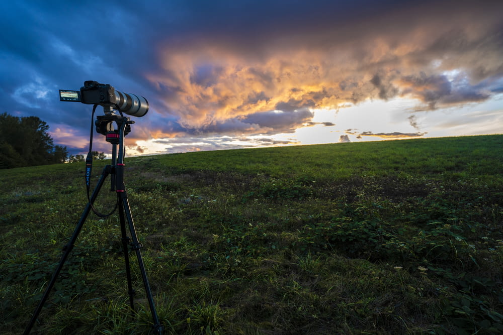 a camera set up on a tripod in a field