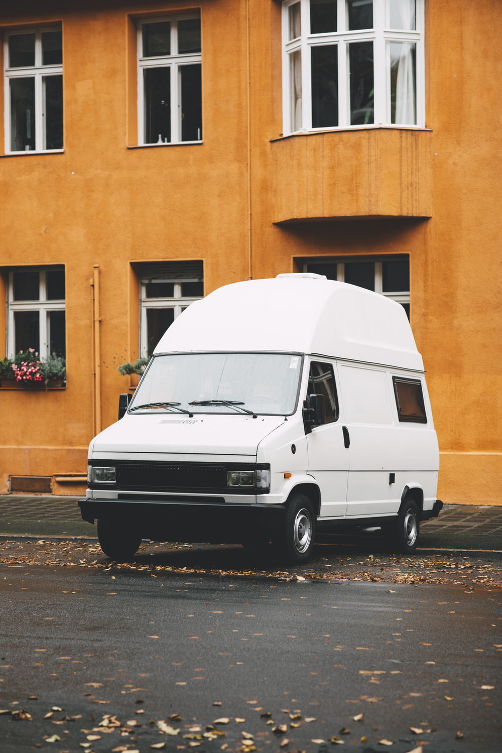 a white van parked in front of a yellow building