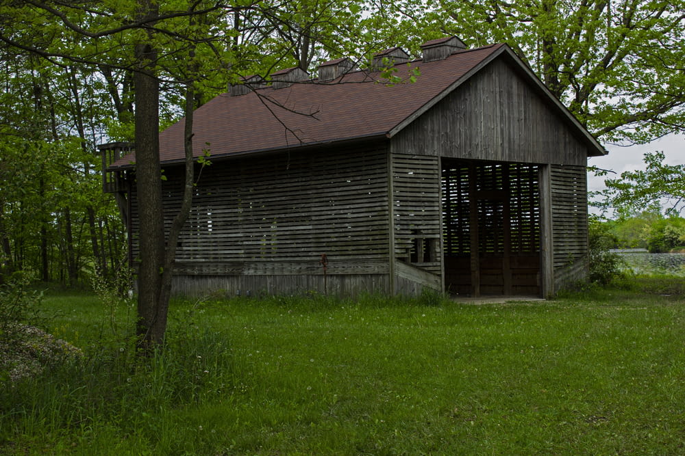 um velho edifício de madeira sentado no meio de um campo