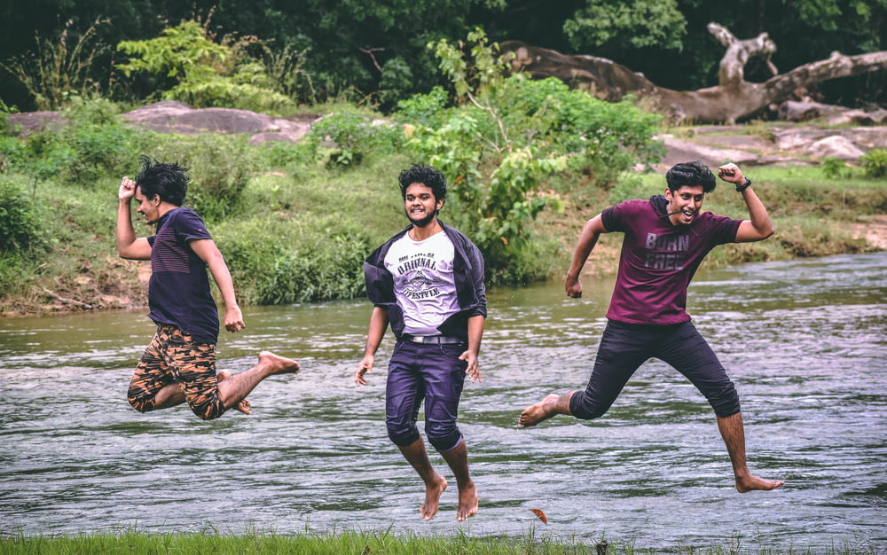 Un groupe de jeunes hommes sautant dans une rivière
