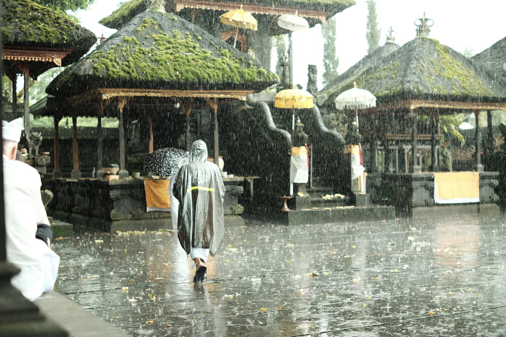 a man walking in the rain with an umbrella