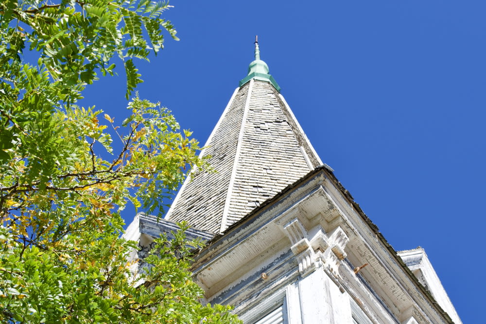a tall white building with a green steeple