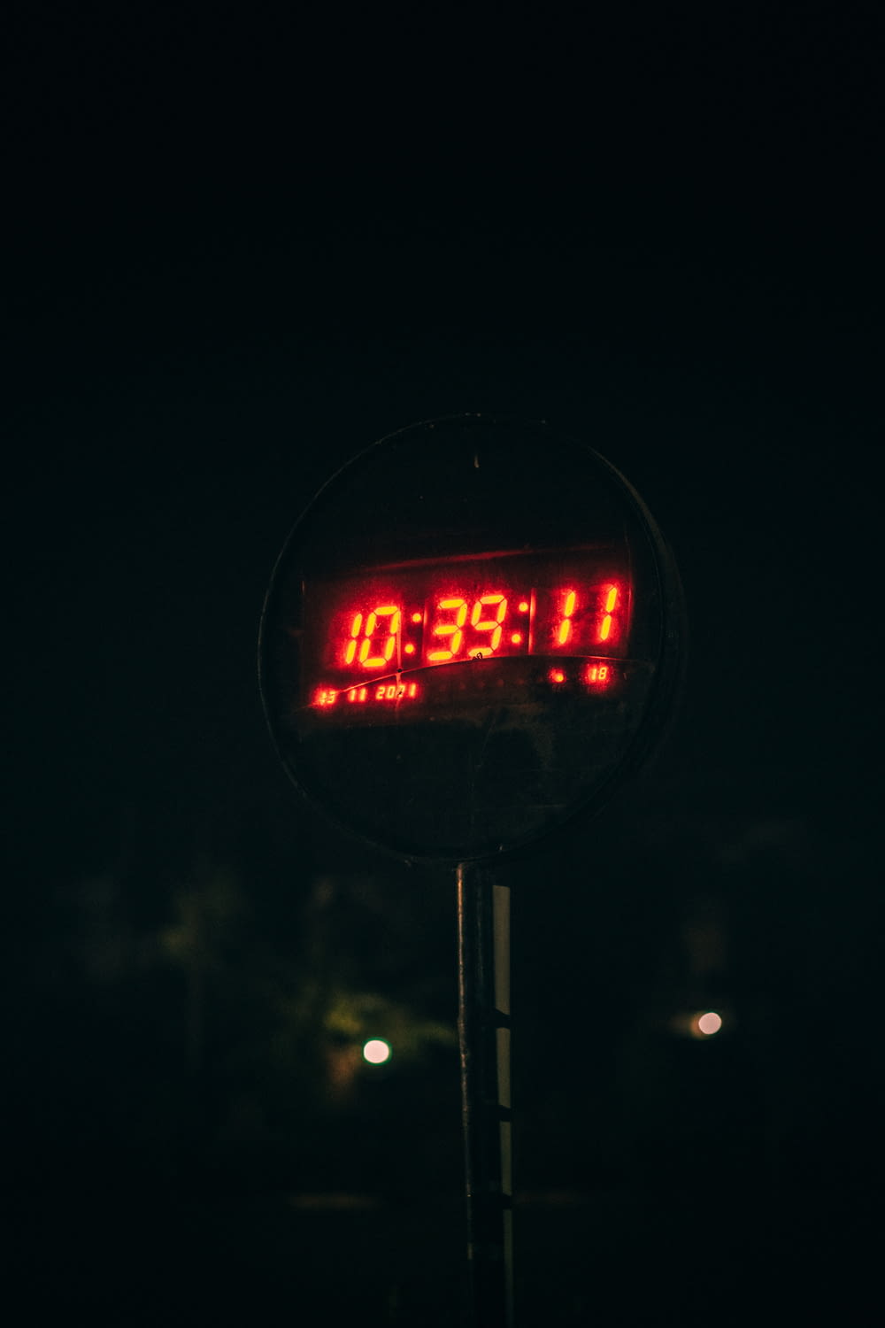 a clock that is on a pole in the dark
