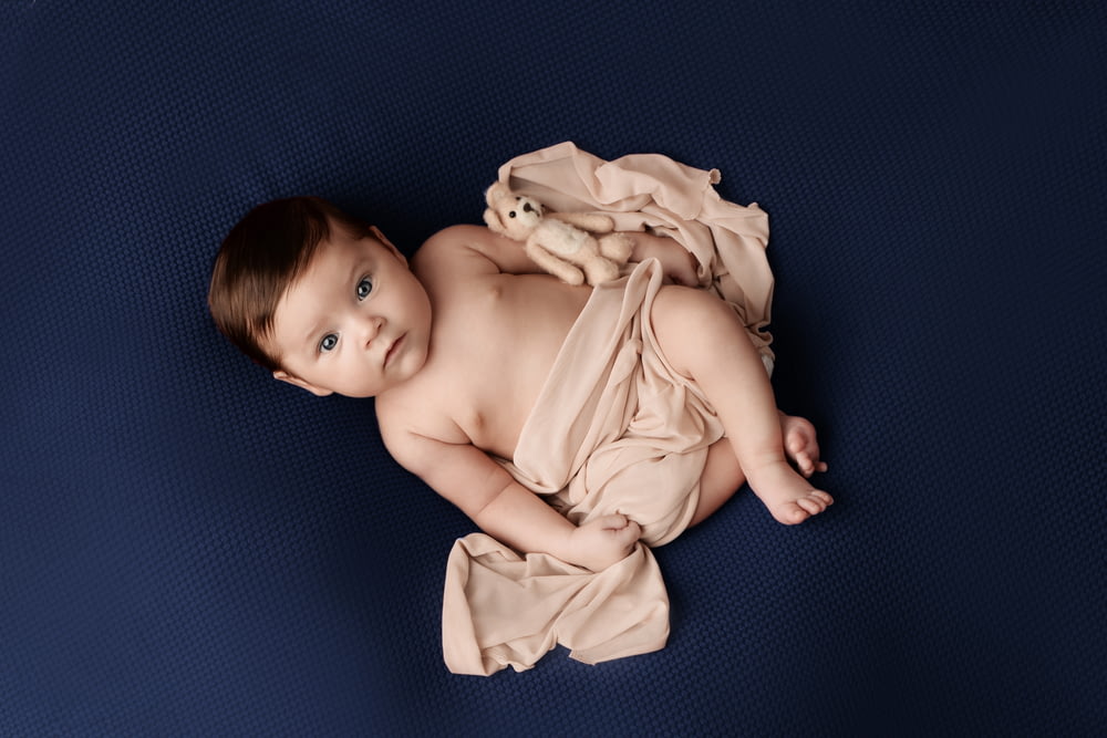 a baby is laying on a blue blanket