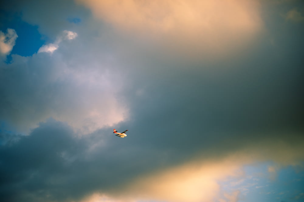 a small plane flying through a cloudy sky