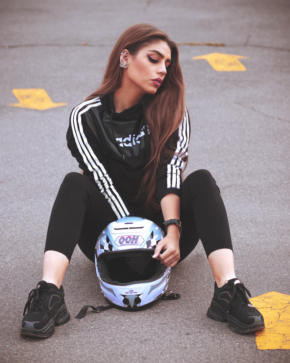 a woman sitting on the ground with a helmet