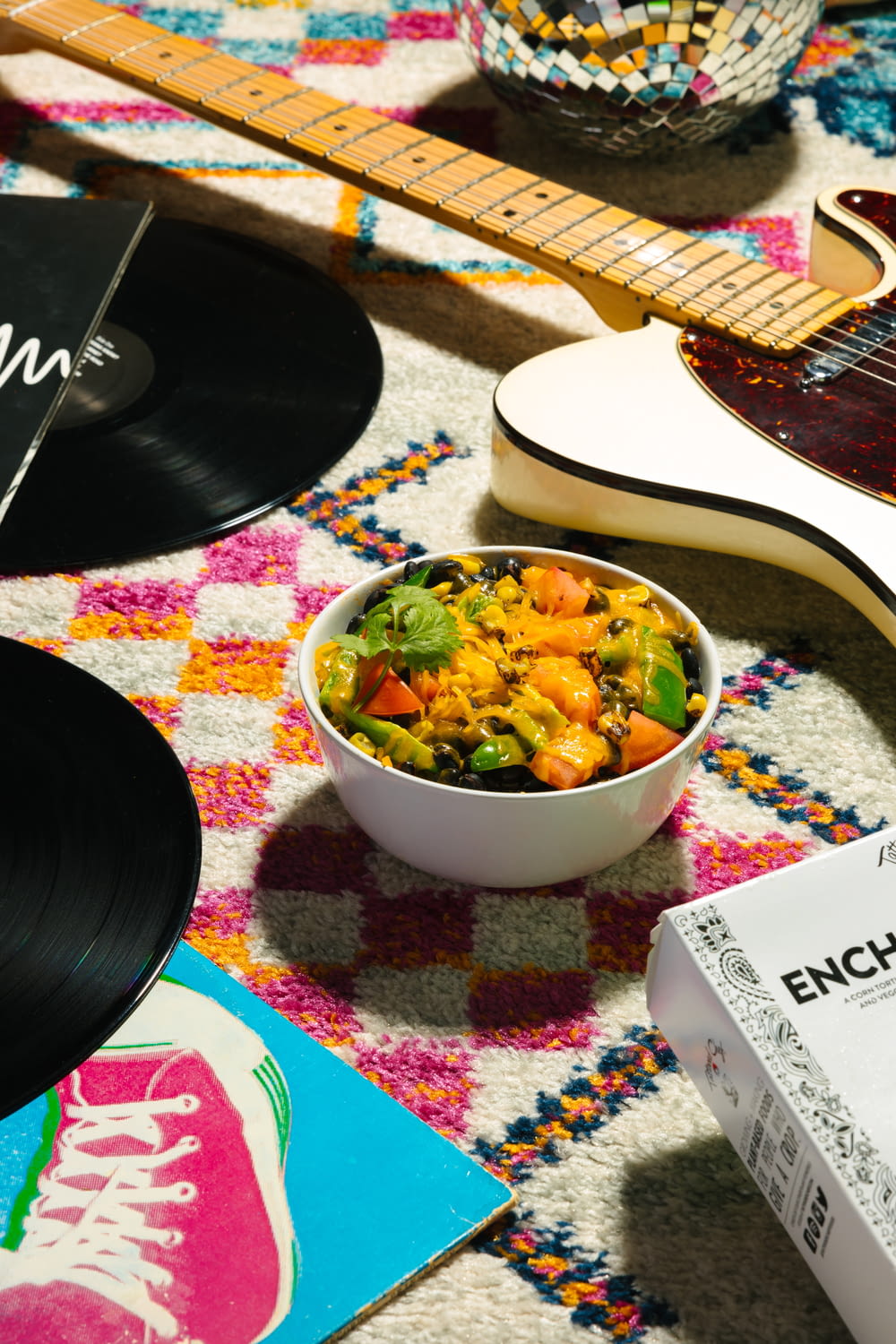 a bowl of food sitting on top of a table next to a guitar