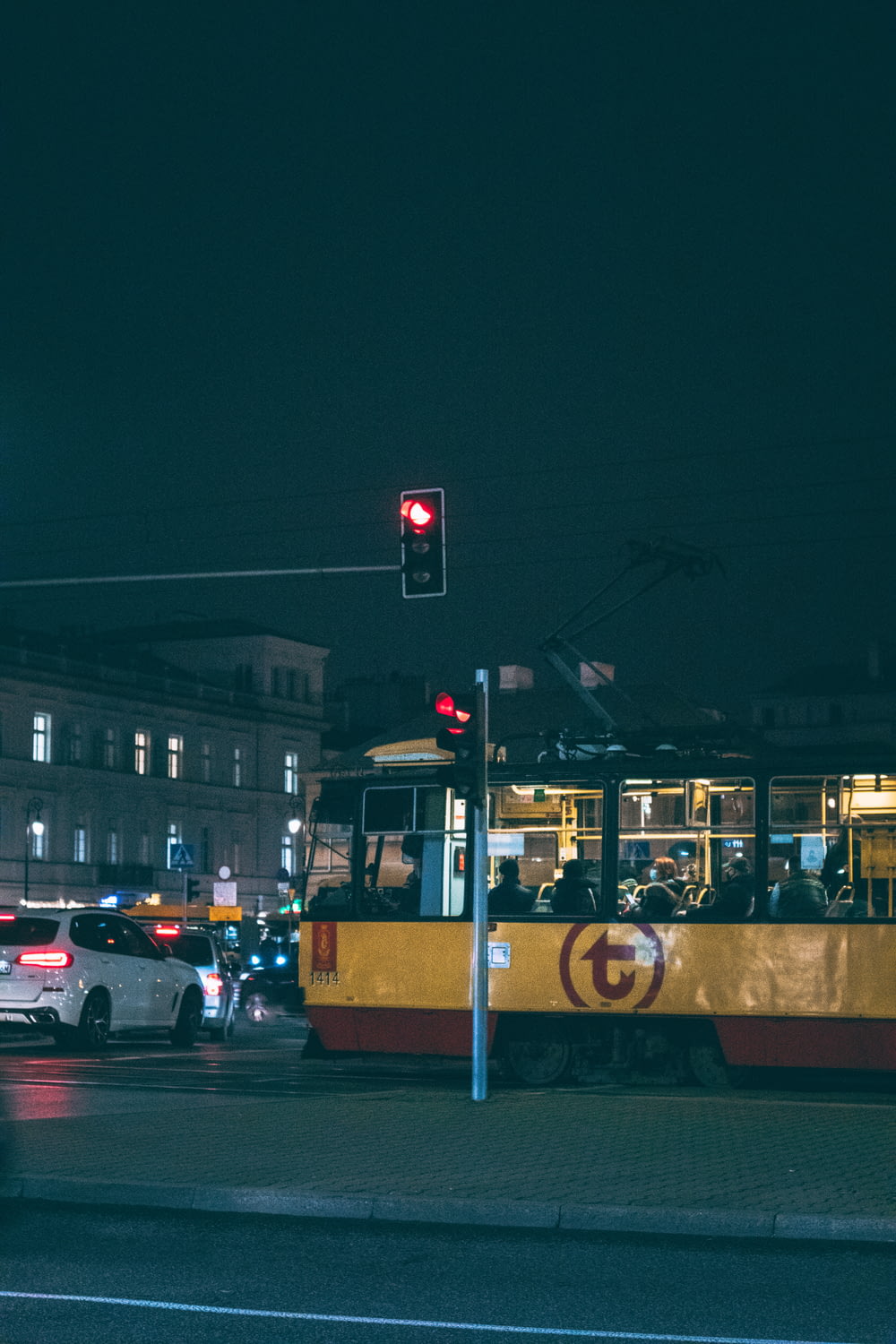 a yellow and red trolley on a city street at night