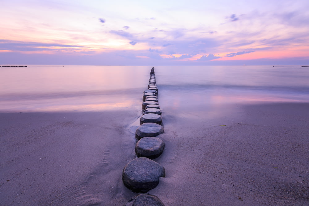 a row of rocks sitting on top of a sandy beach