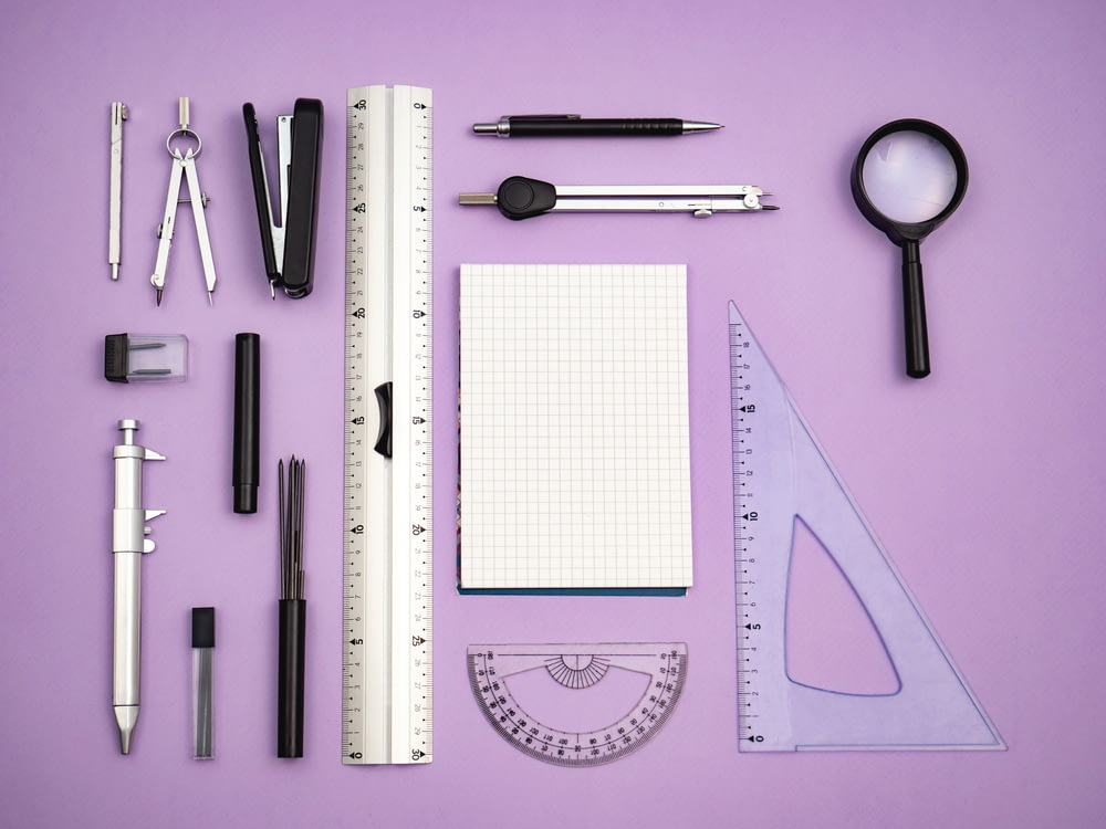 une variété de fournitures de bureau disposées sur une surface violette