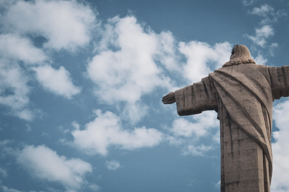 a large statue of jesus on a cloudy day