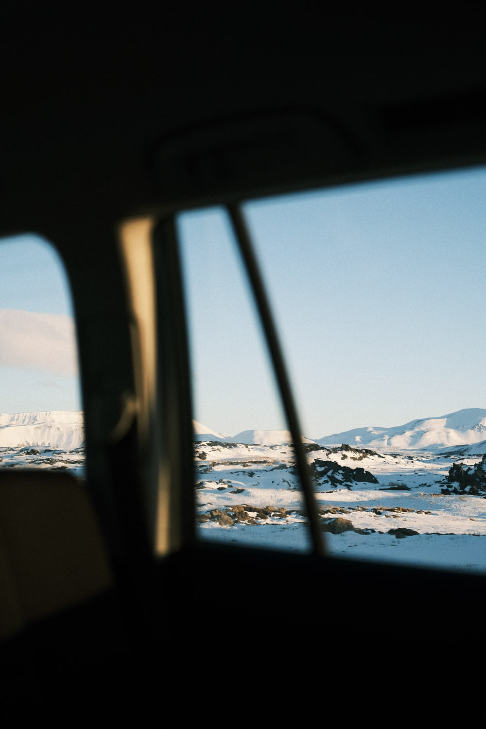 a view of a snowy landscape from a car window