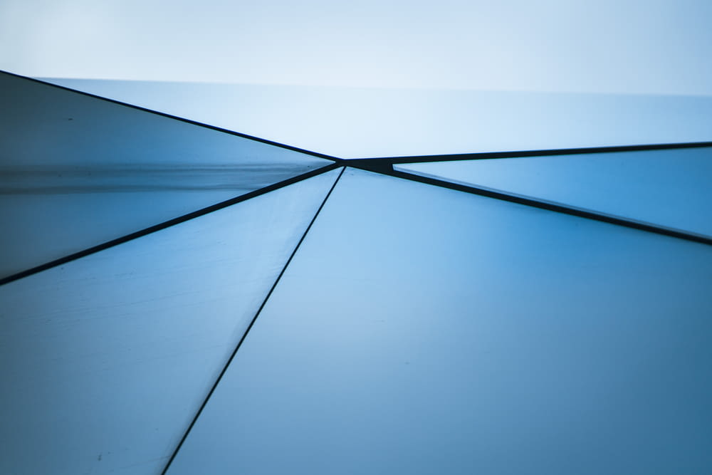 a close up of a metal surface with a blue sky in the background
