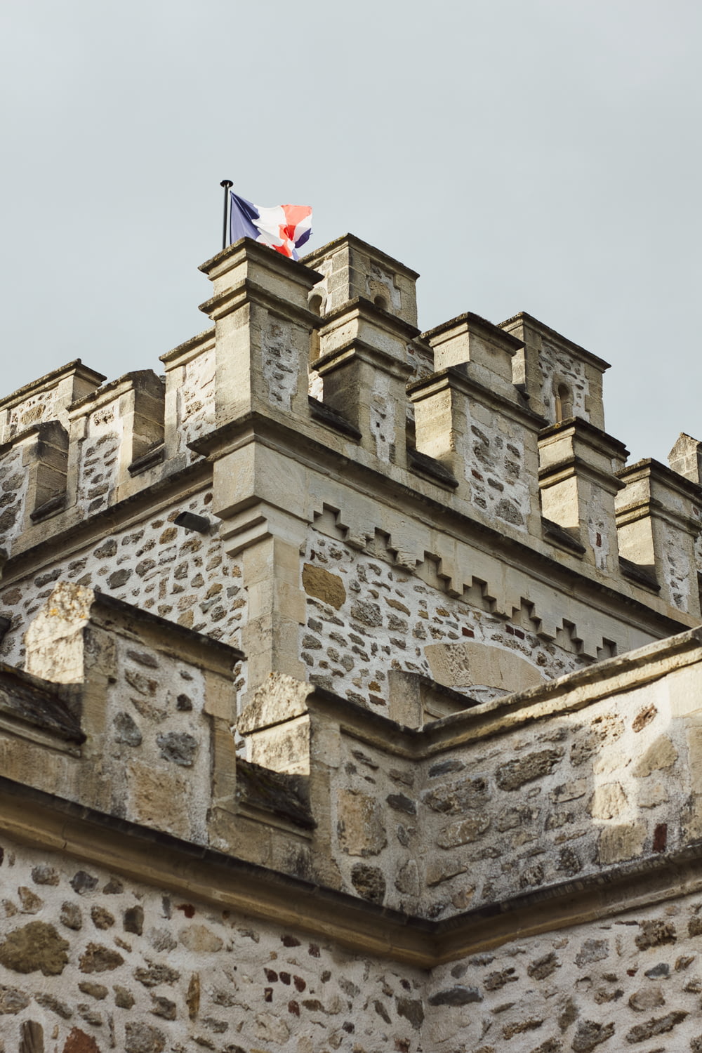 a stone building with a flag on top of it