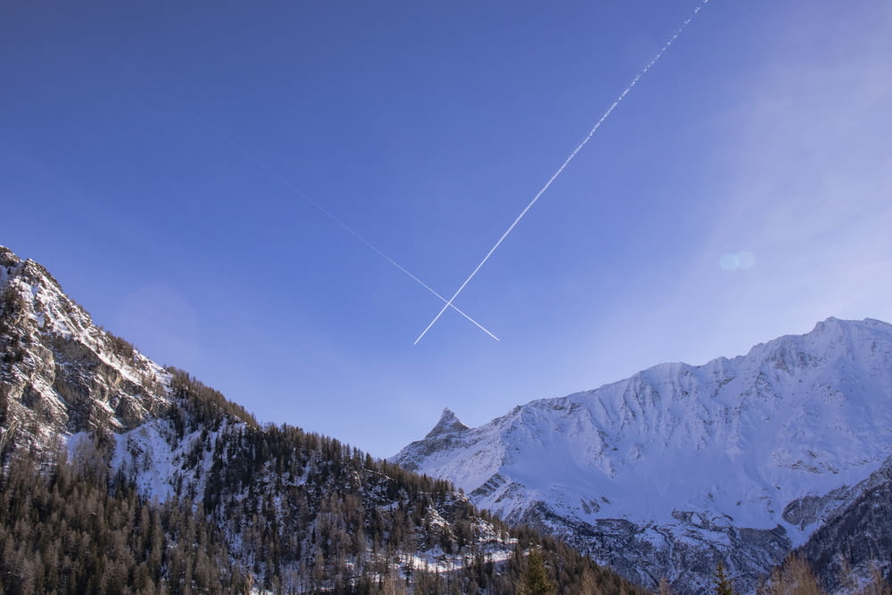 a plane is flying over a snowy mountain range