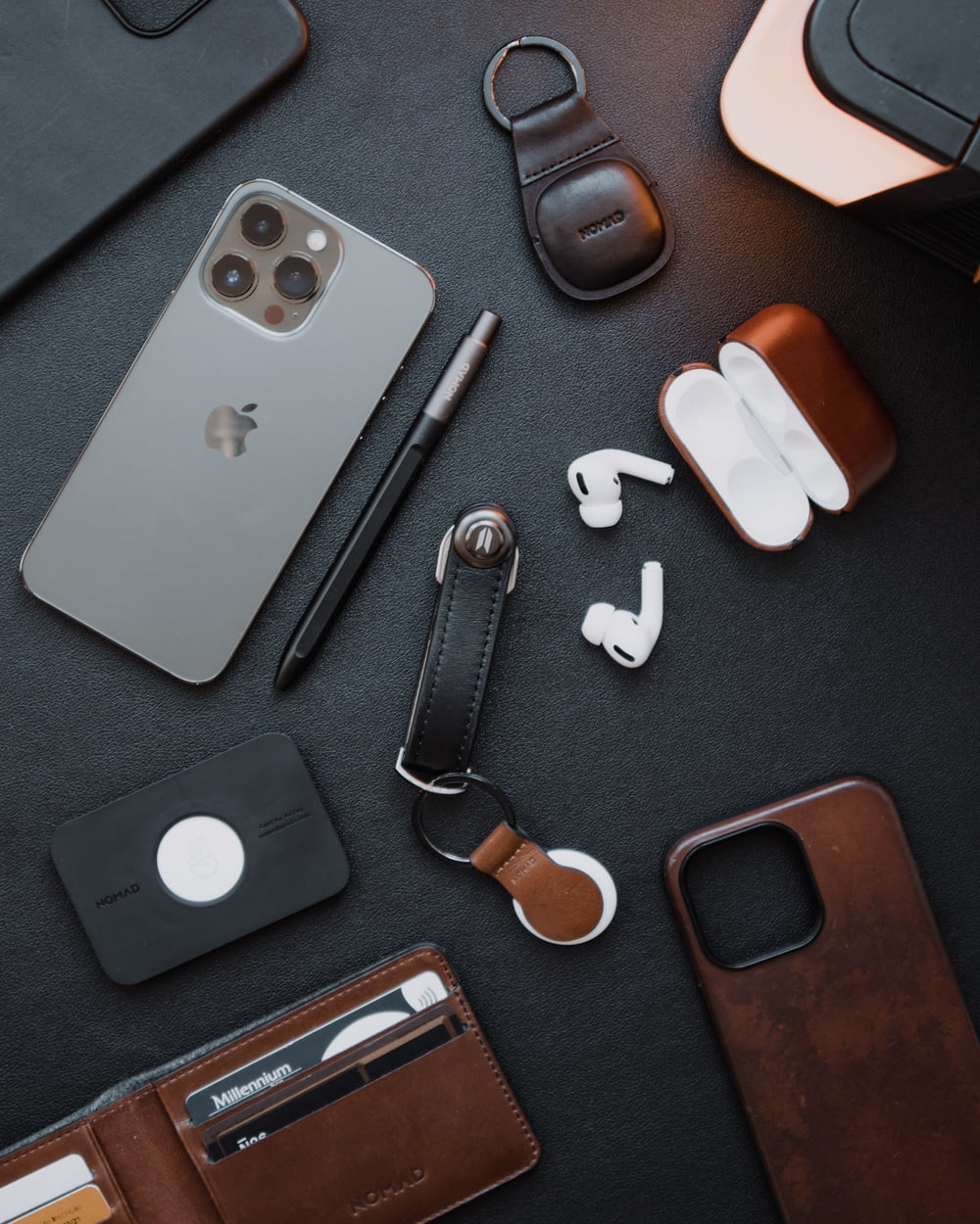 a cell phone, wallet, earbuds, and other items laid out on