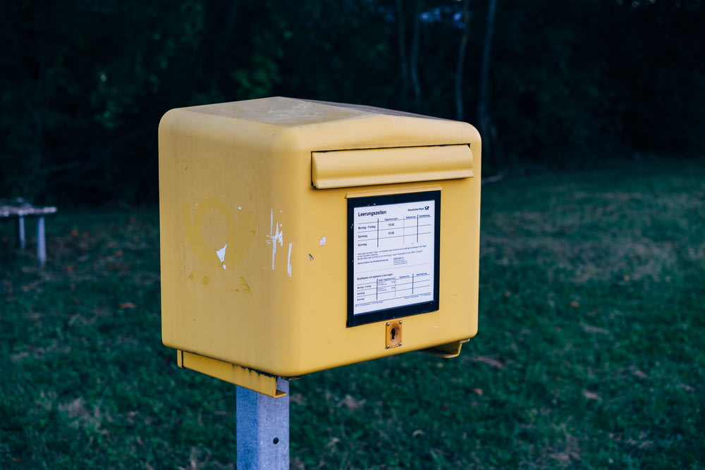 a yellow box sitting on top of a metal pole