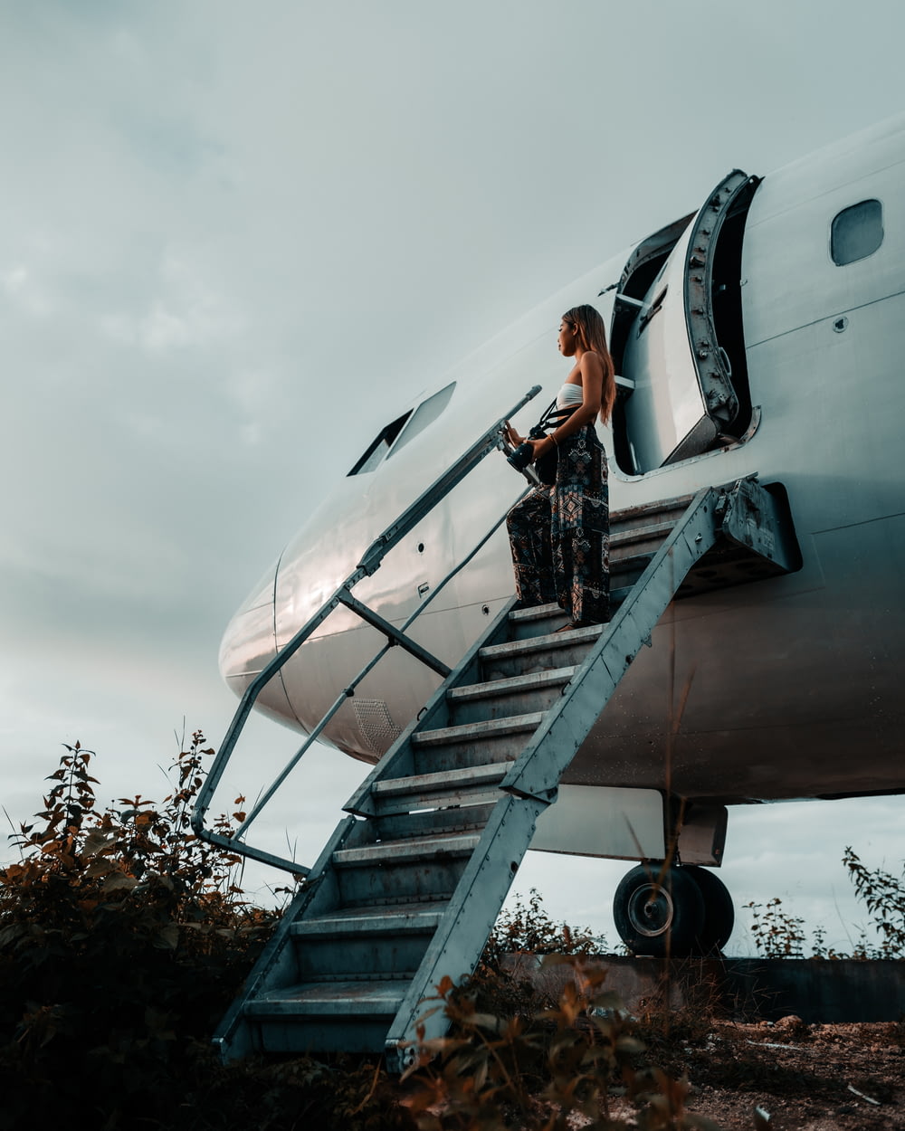 a woman standing on the steps of an airplane