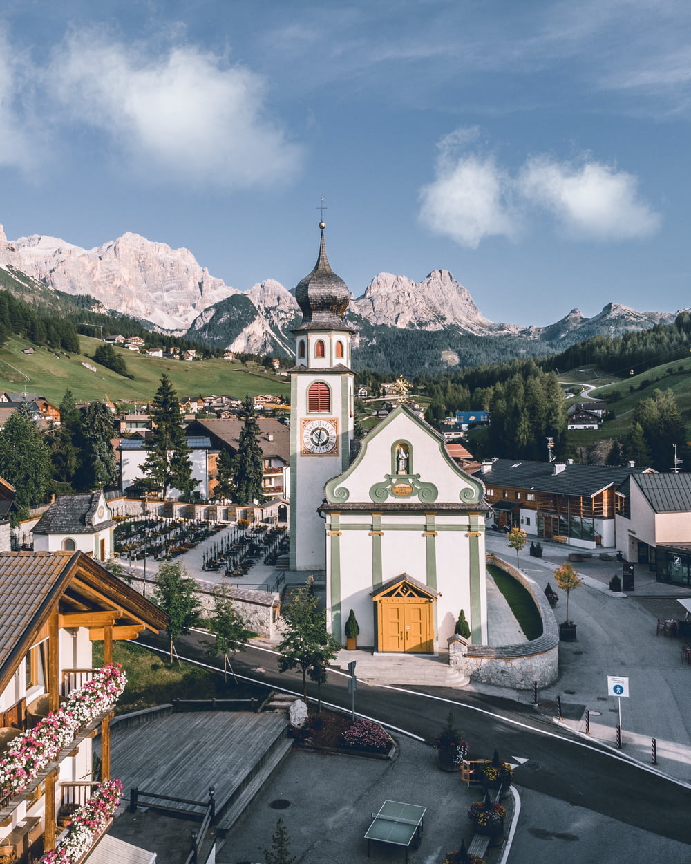 a small town with a church and mountains in the background