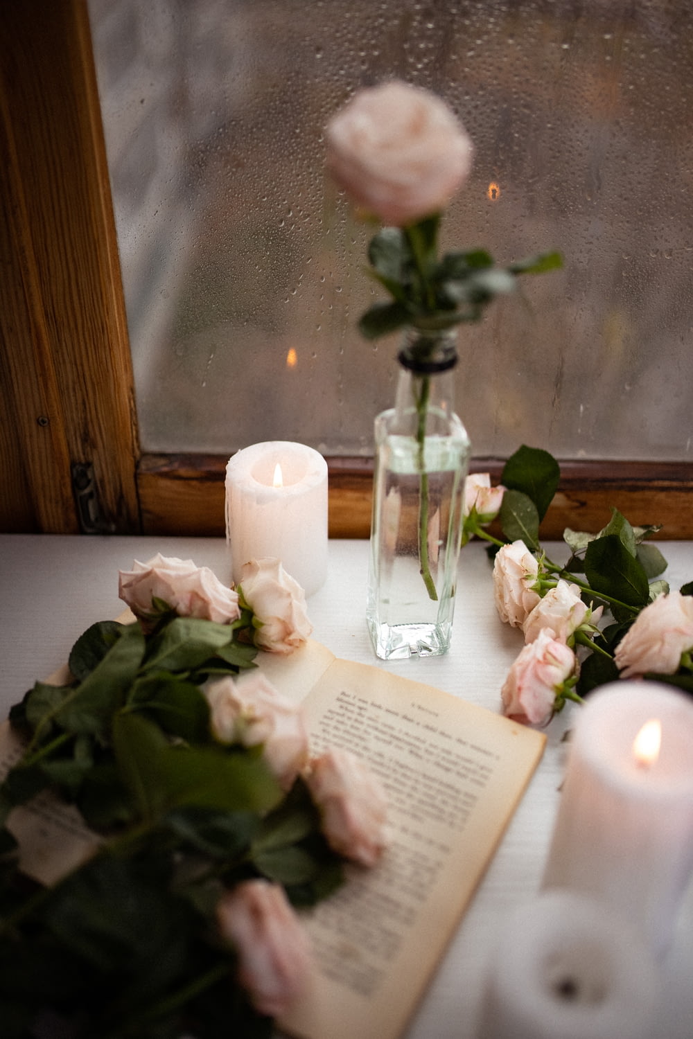 a window sill with roses and a book on it