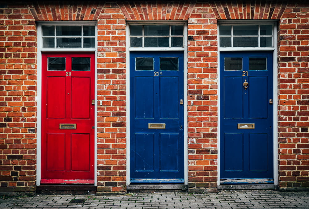 two red and blue doors on a brick building