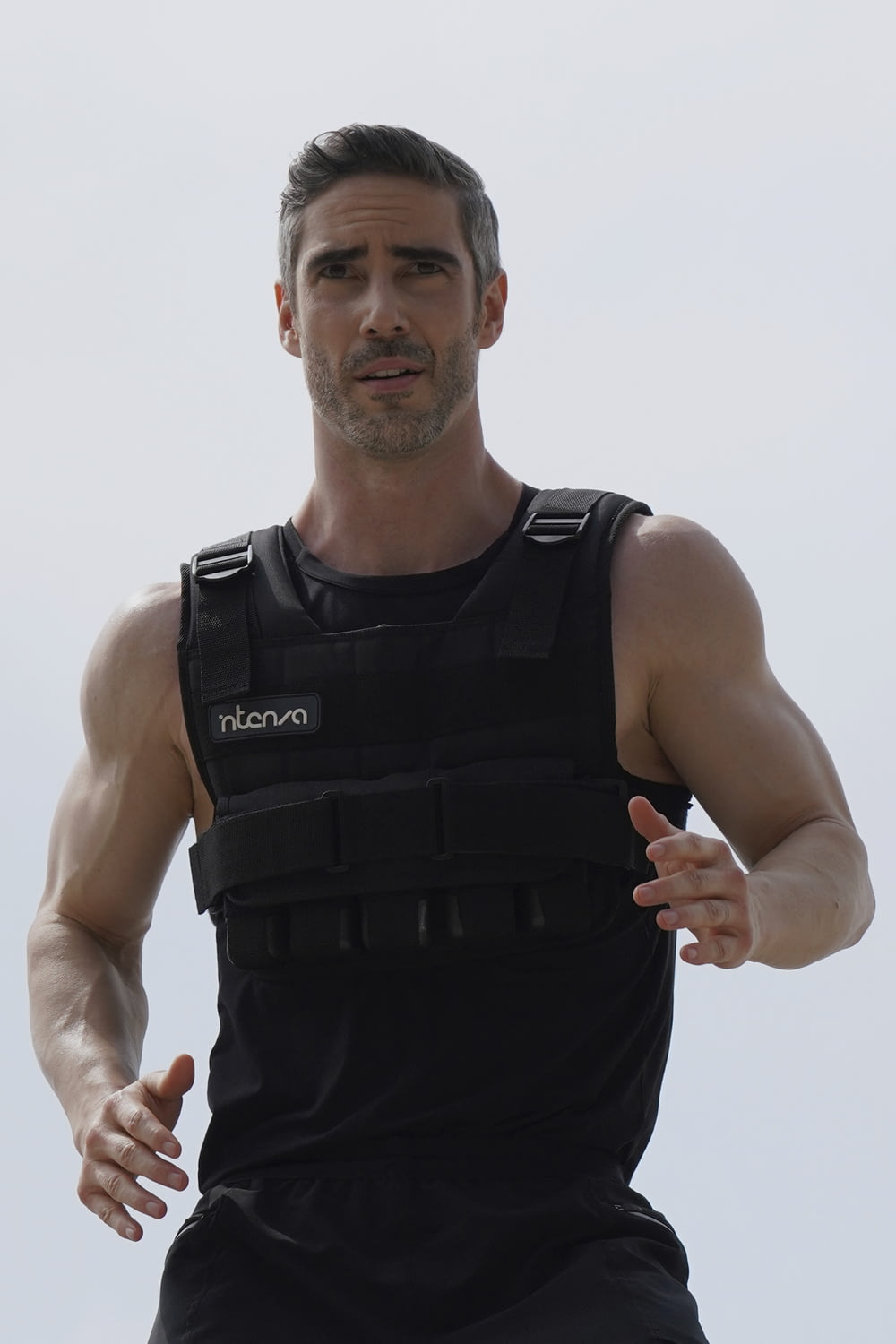 a man in a black vest is running