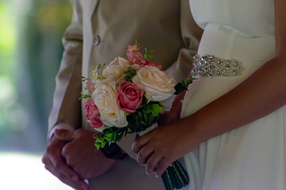 a close up of a person holding a bouquet of flowers