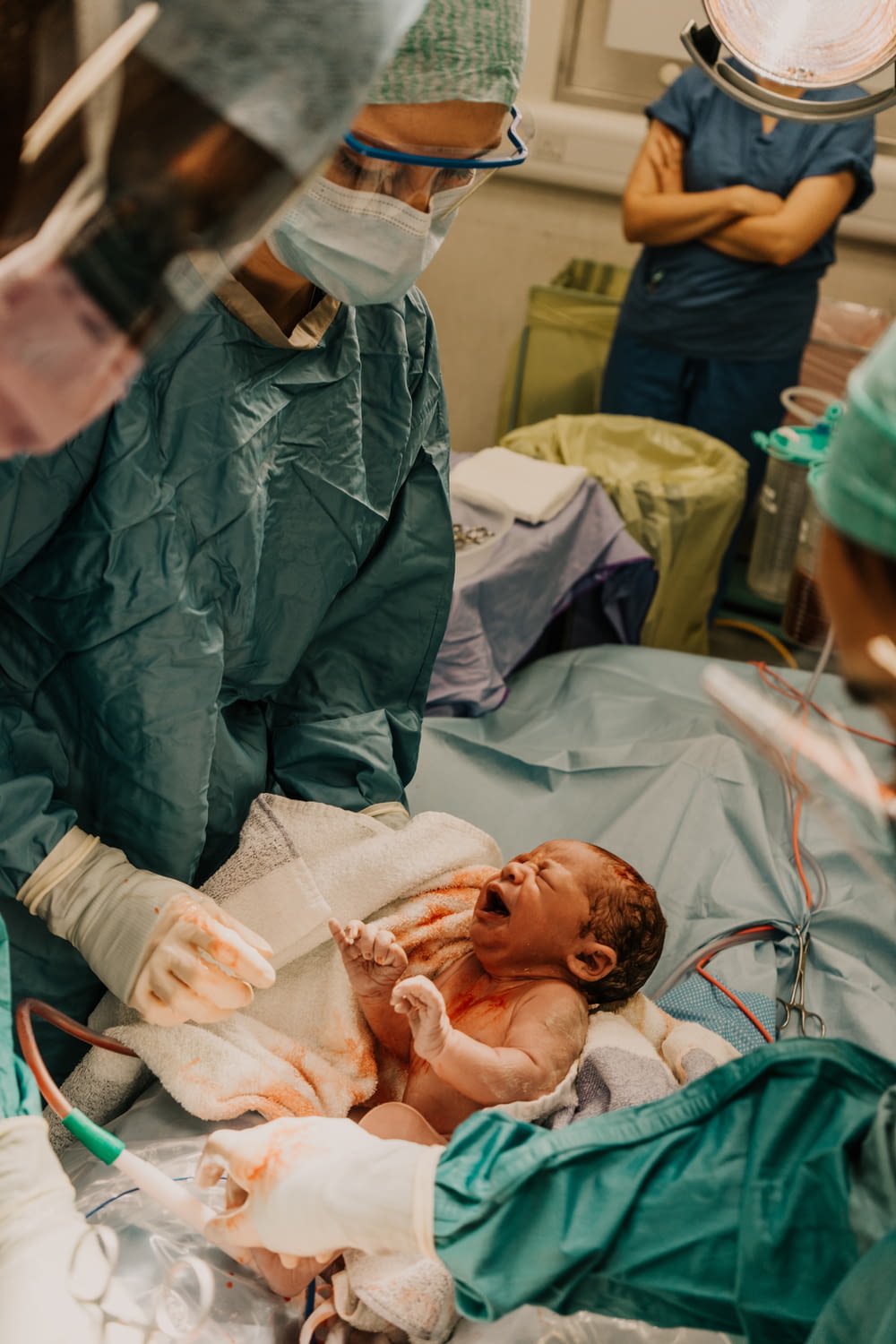 un bebé en una cama de hospital con personal médico a su alrededor