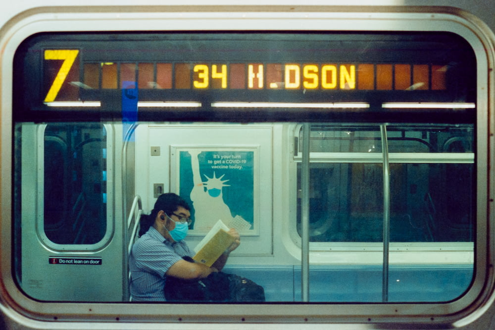 a man reading a book while sitting on a train