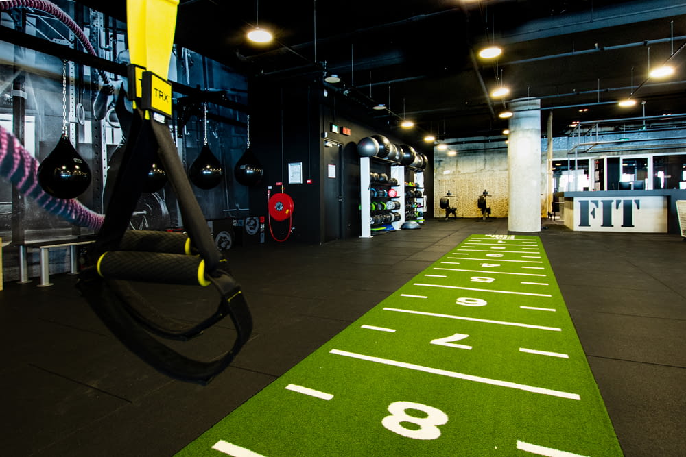 a gym with a green floor and white numbers on it
