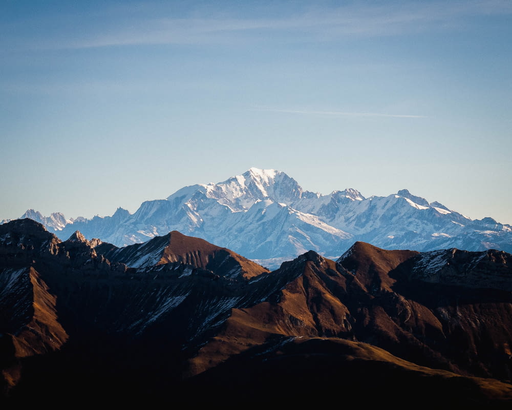 a mountain range with snow capped mountains in the background
