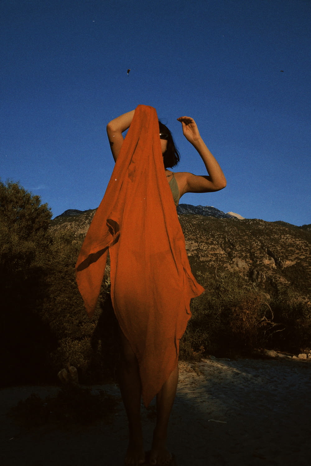 a woman in an orange dress standing in the desert
