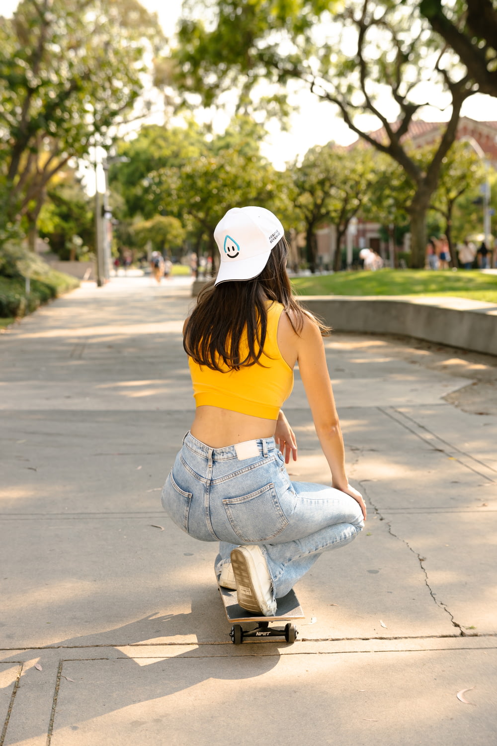 a woman riding a skateboard down a sidewalk