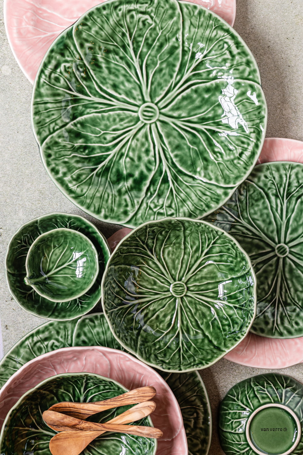 a collection of green and pink plates and bowls
