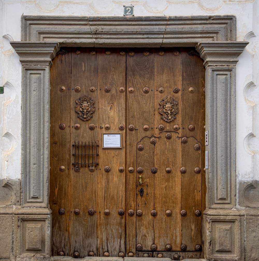 a large wooden door with a sign on it