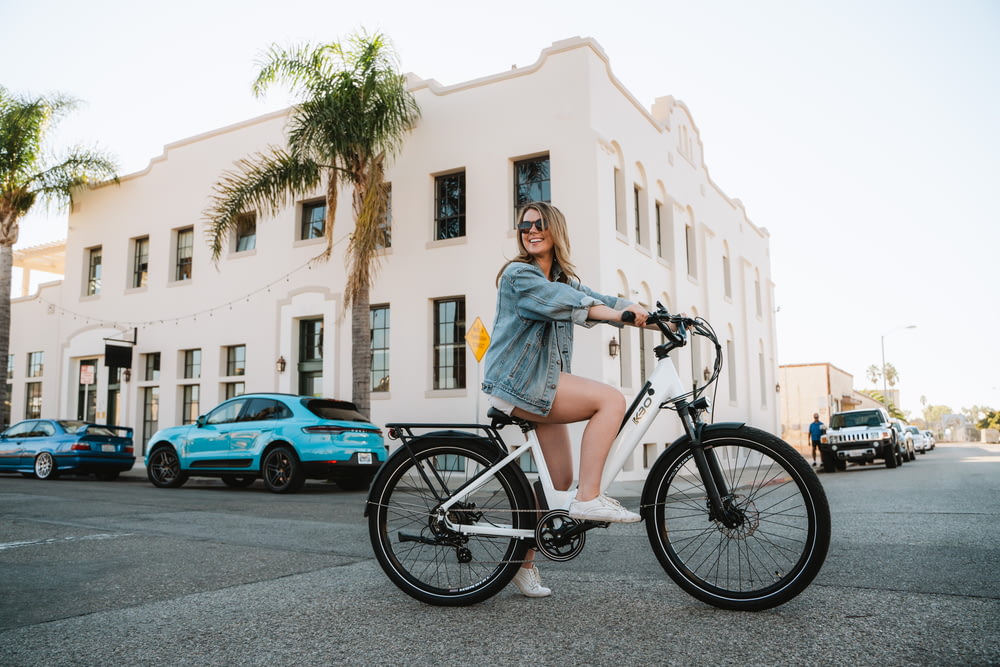 a woman riding a bike on a city street