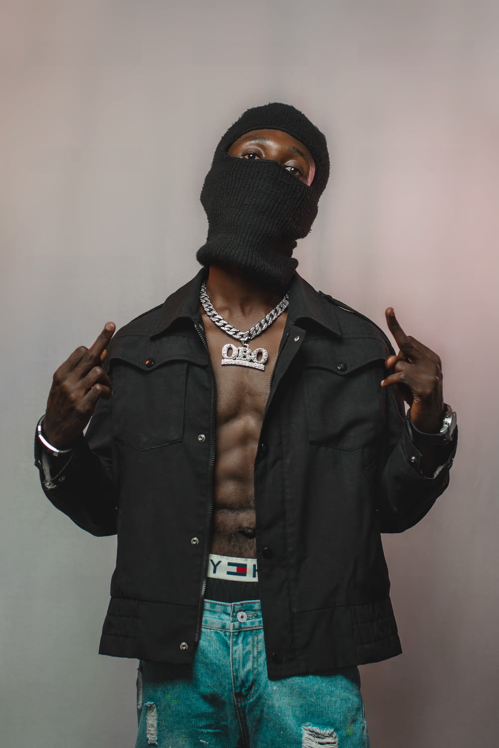 a shirtless man wearing a black mask and jeans