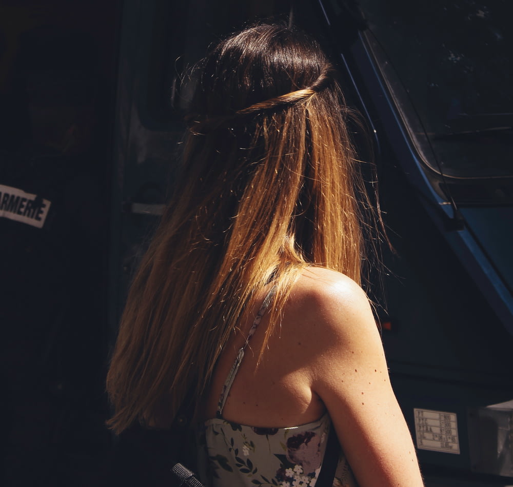 a woman with long hair standing in front of a bus