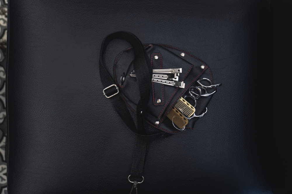 a black purse with a black strap and a gold lock